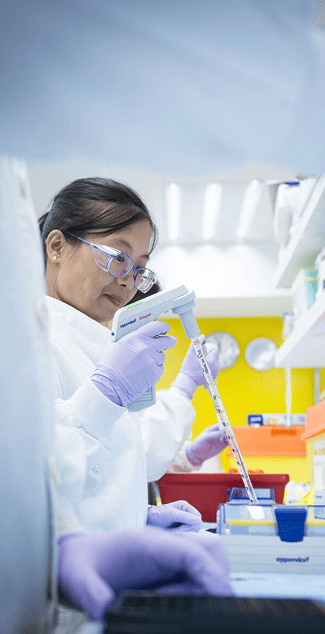 Pesquisadora em laboratório da AstraZeneca simbolizando ciência e inovação em oncologia, com foco em tratamentos transformadores contra o câncer